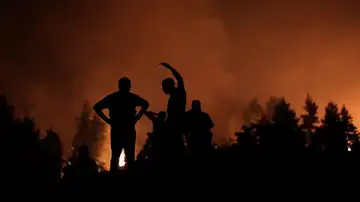 Voluntarios esperan apoyo en un incendio en Grecia