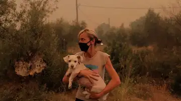 Una mujer pone a salvo del fuego a su perro en Grecia