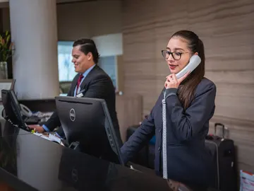 Dos recepcionistas en el hotel en que trabajan Dos recepcionistas en el hotel en que trabajan