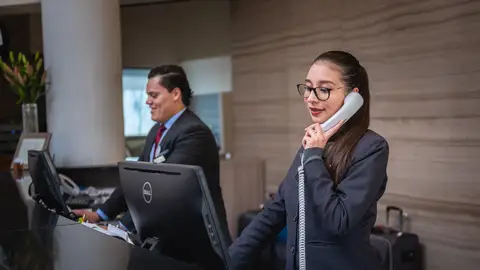 Dos recepcionistas en el hotel en que trabajan