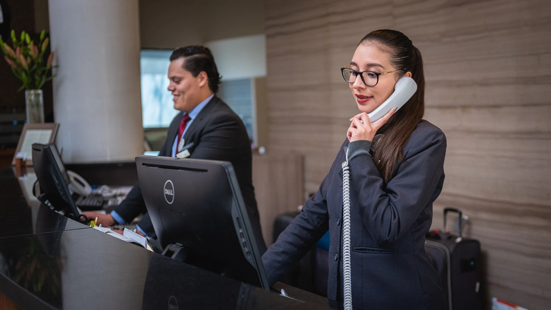 Dos recepcionistas en el hotel en que trabajan Dos recepcionistas en el hotel en que trabajan