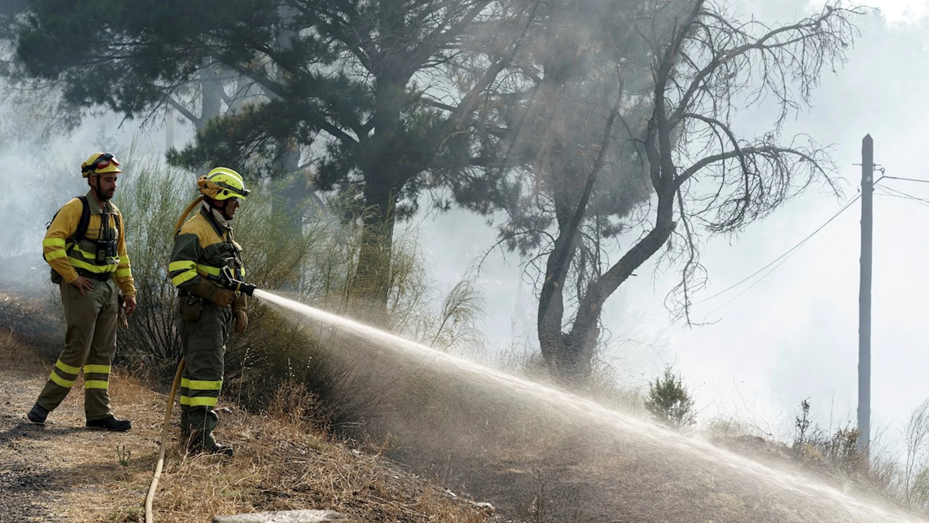 Dos bomberos intentan apagar un fuego en el municipio abulense de El Tiemblo