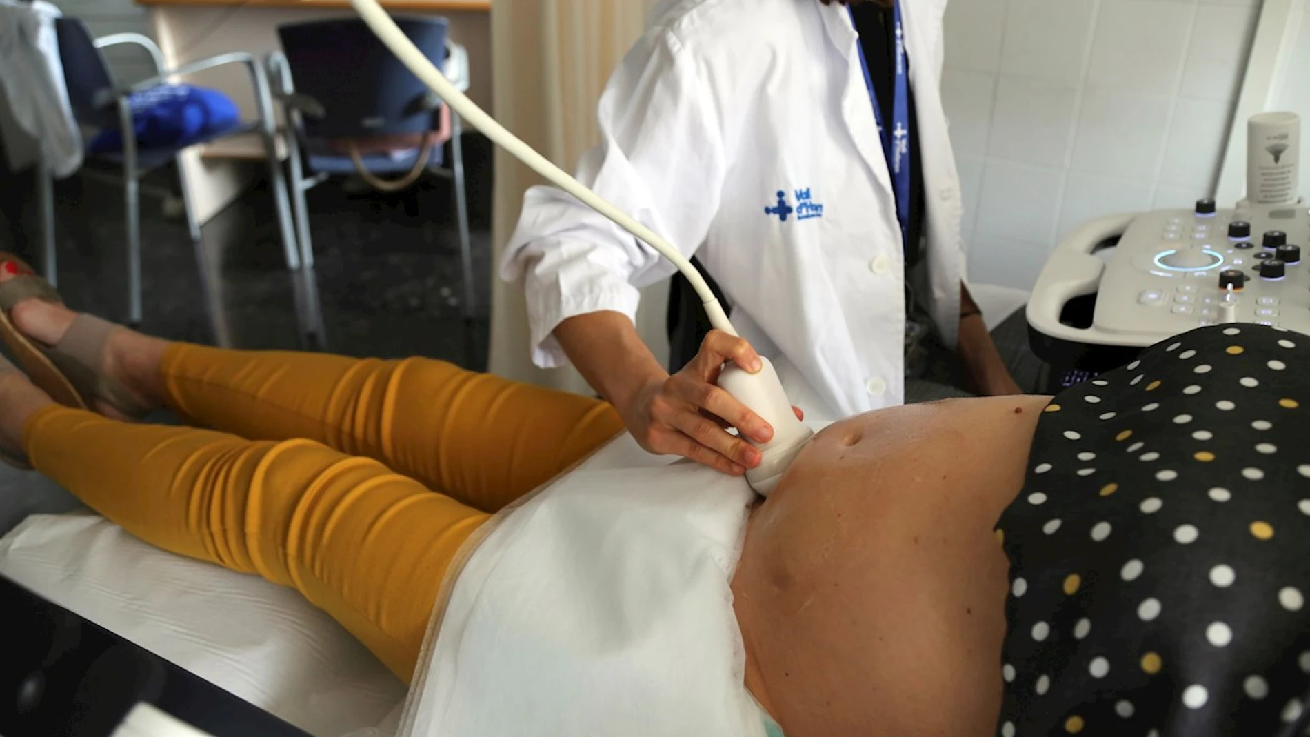 Una sanitaria hace una ecografía a una embarazada antes de ponerle la vacuna en el Hospital Vall d'Hebron de Barcelona