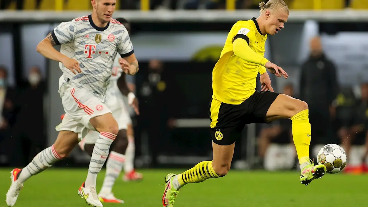 Erling Haaland conduce el balón seguido por Niklas Suele en la final de la Supercopa alemana Erling Haaland conduce el balón seguido por Niklas Suele en la final de la Supercopa alemana