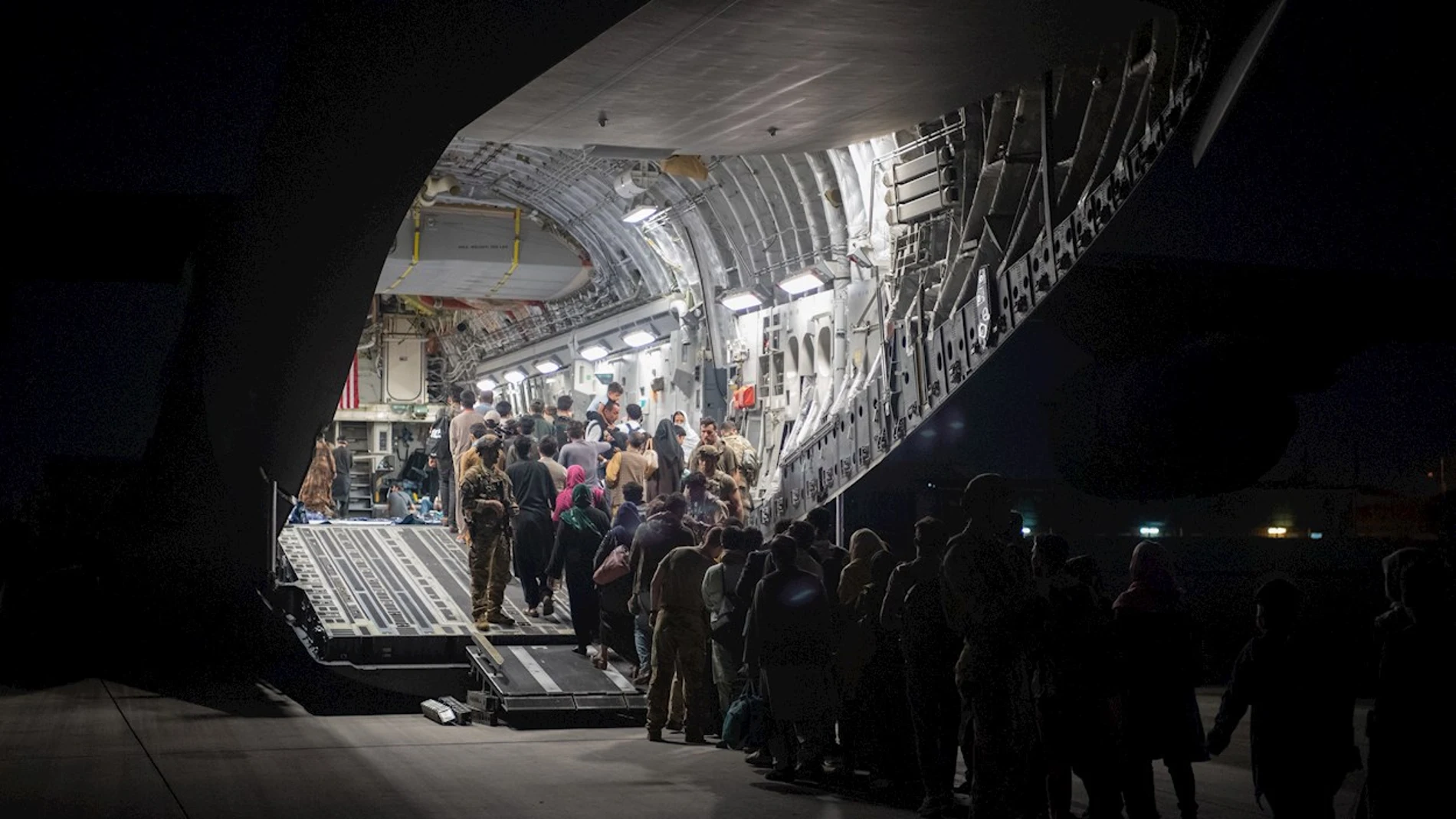 Un grupo de afganos sube a un avión en el aeropuerto de Kabul