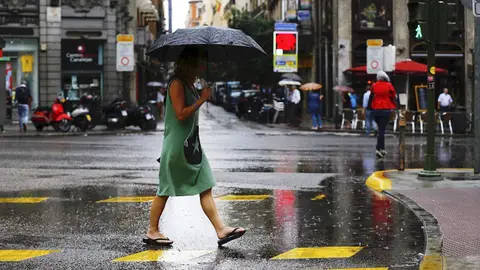 Una mujer se protege de la lluvia en el centro de Madrid. Una mujer se protege de la lluvia en el centro de Madrid.