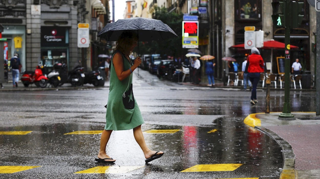 Una mujer se protege de la lluvia en el centro de Madrid. Una mujer se protege de la lluvia en el centro de Madrid.