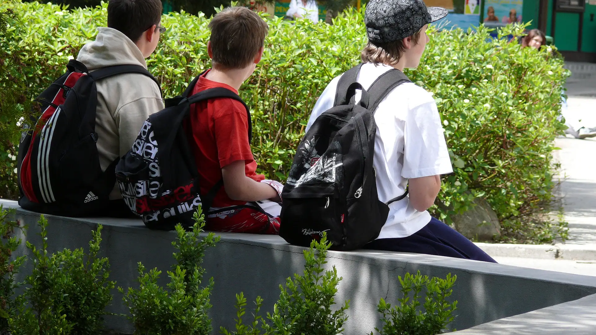 Niños sentados con mochila Niños sentados con mochila