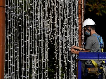 Un operario coloca una cortina de luces led en el Parque de San Francisco en Oviedo, para las próximas fiestas de la ciudad