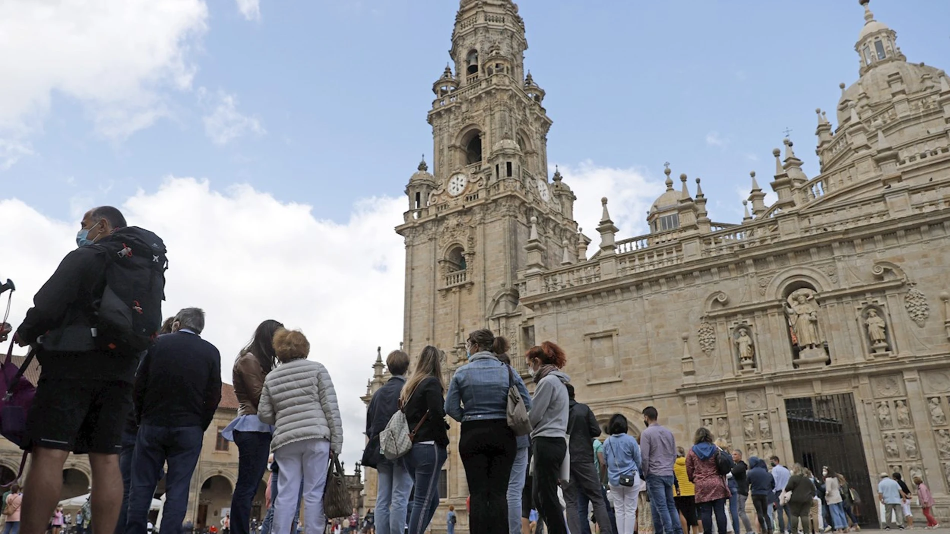 Turistas y peregrinos hacen cola para entrar a la catedral de Santiago de Compostela por la Puerta Santa
