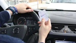 Foto de archivo: Un hombre sostiene un carnet de conducir Foto de archivo: Un hombre sostiene un carnet de conducir