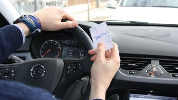 Foto de archivo: Un hombre sostiene un carnet de conducir 