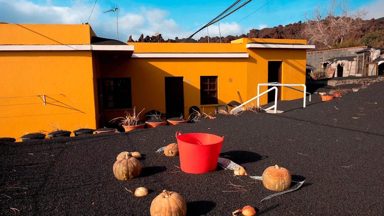 Una gruesa capa de ceniza y escoria cubre el techo de las viviendas del barrio de Las Manchas, en La Palma, y los terrenos adyacentes, dentro de la zona evacuada por su proximidad al volc&aacute;n