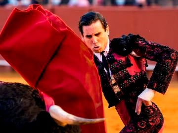 El diestro Juan Ortega da un pase con la muleta al segundo de los de su lote, durante la corrida de la Feria de San Miguel celebrada este viernes en la plaza de toros de la Maestranza, en Sevilla