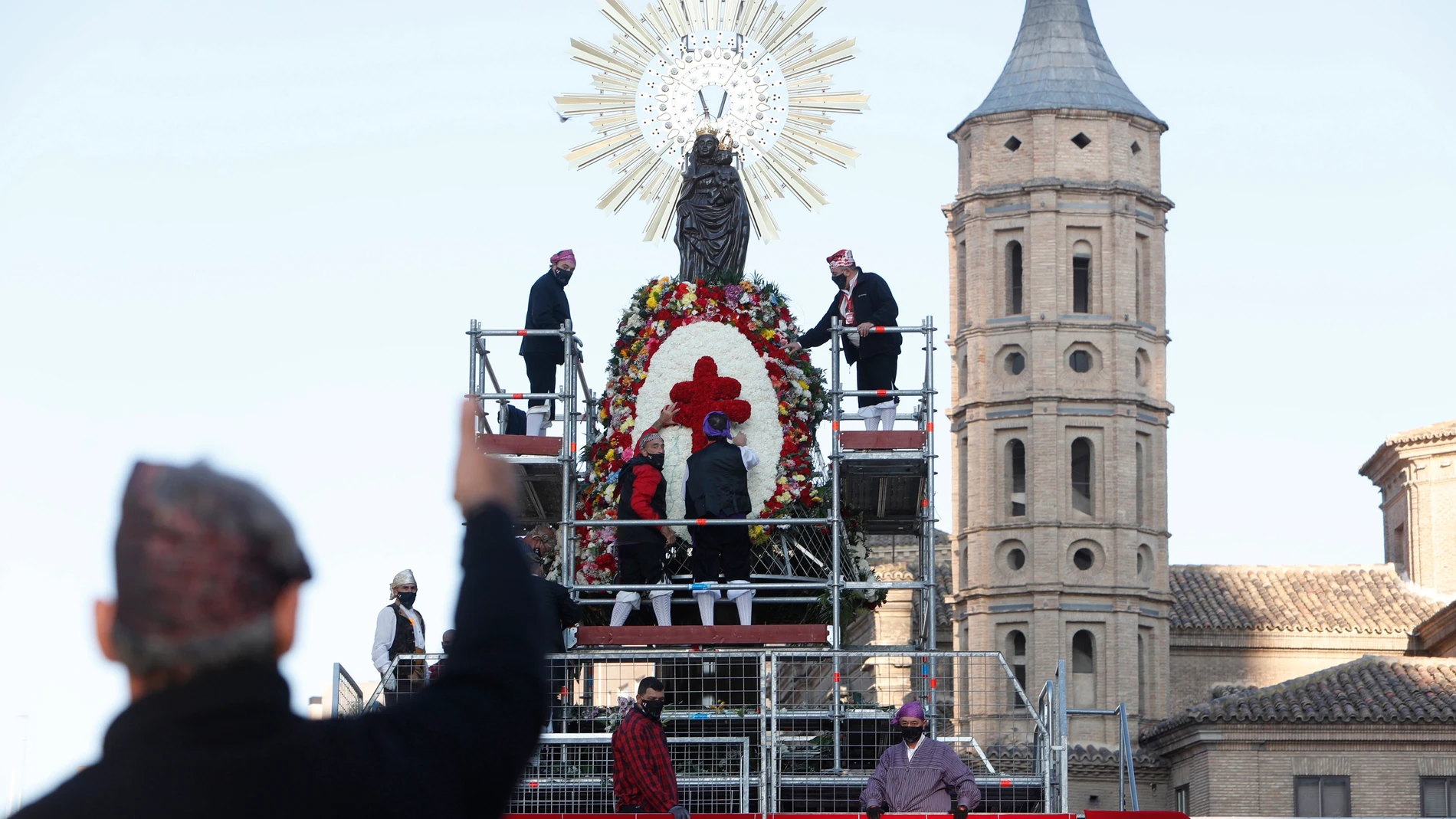 Operarios municipales colocan la Cruz de Lorena en el manto de la Virgen del Pilar de Zaragoza 