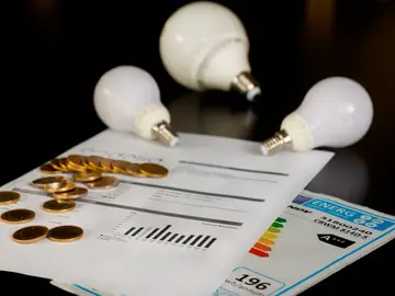 Varias bombillas sobre una factura de la luz