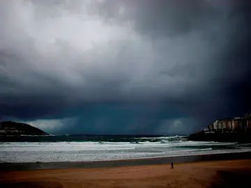 Un hombre pasea a su perro por la playa del Orzán en A Coruña, en una imagen de archivo Un hombre pasea a su perro por la playa del Orzán en A Coruña, en una imagen de archivo
