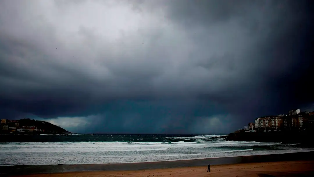 Un hombre pasea a su perro por la playa del Orzán en A Coruña, en una imagen de archivo Un hombre pasea a su perro por la playa del Orzán en A Coruña, en una imagen de archivo