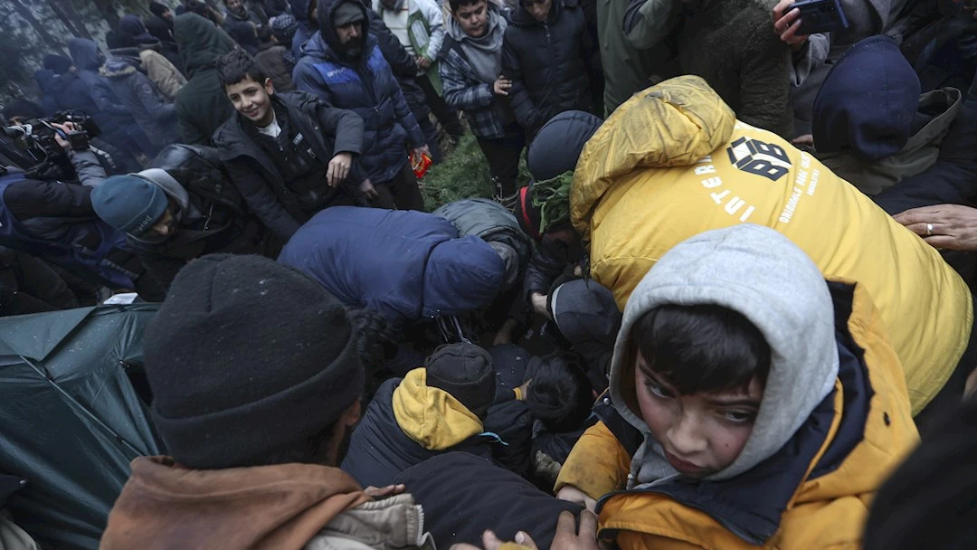 Migrantes luchan por acceder a la comida en uno de capamentos de la frontera de Bielorrusia con Polonia, en la regi&oacute;n de Grodno.