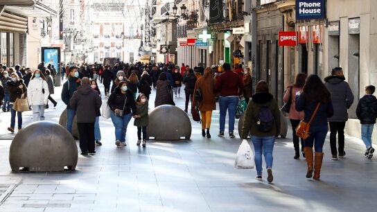 Gente en la calle con mascarillas en v&iacute;spera de Navidad