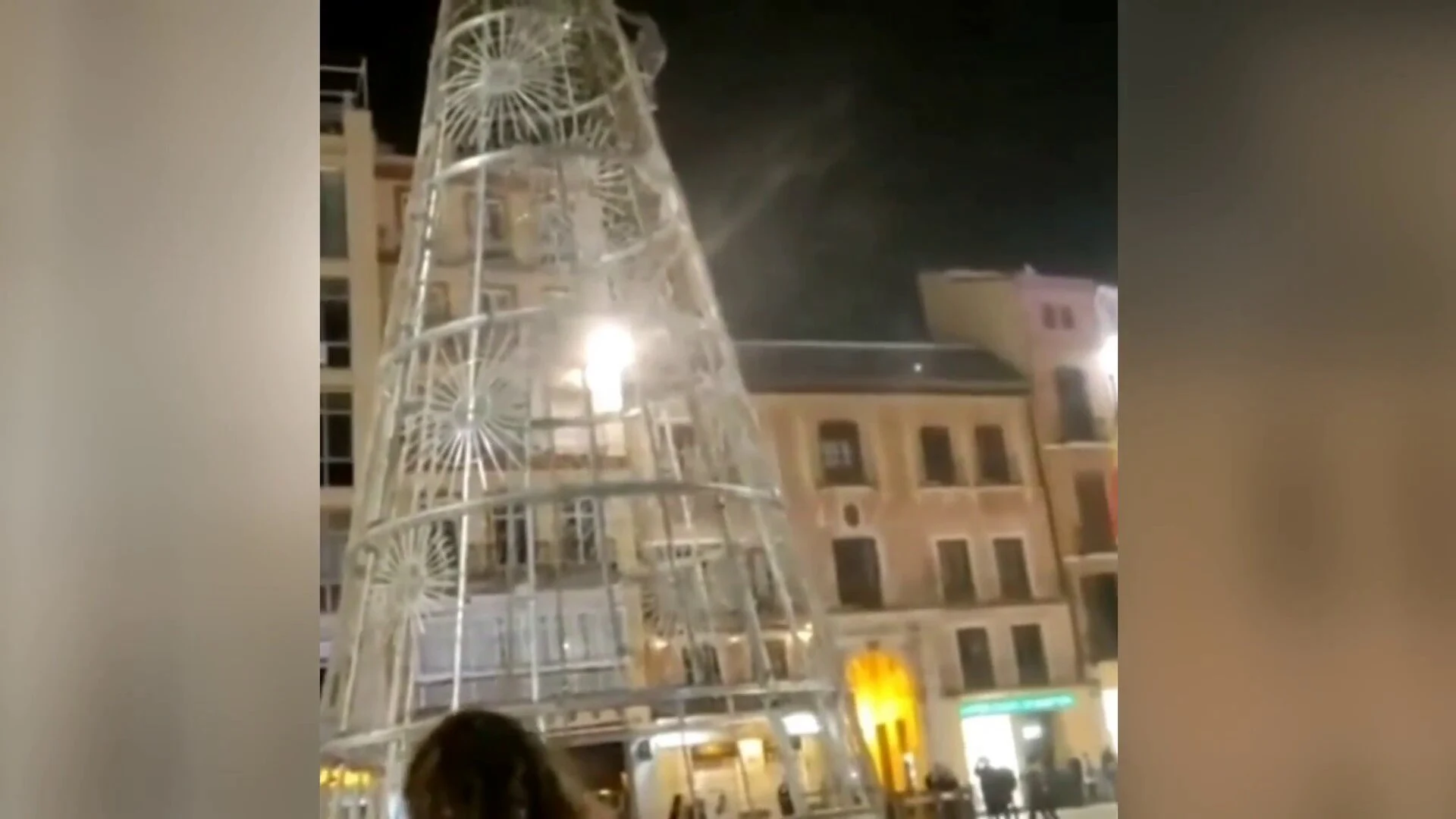 Un joven escala el &aacute;rbol de Navidad de la Plaza de la Constituci&oacute;n en M&aacute;laga