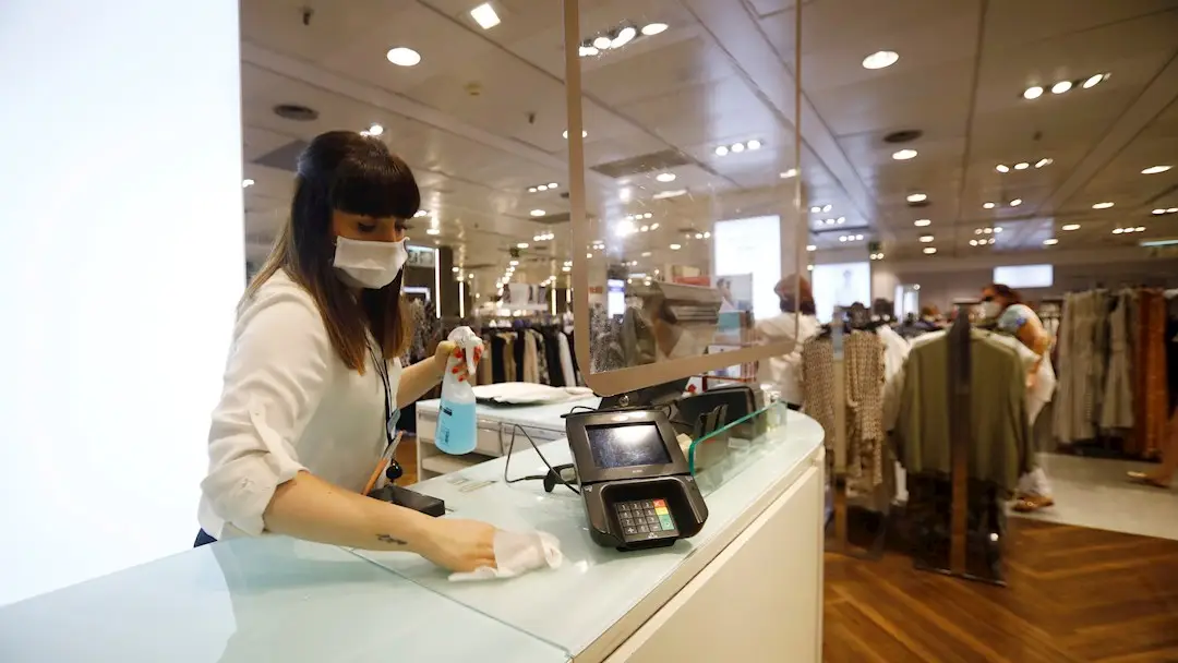 Una empleada desinfecta el mostrador de la tienda de un centro comercial, en una imagen de archivo Una empleada desinfecta el mostrador de la tienda de un centro comercial, en una imagen de archivo