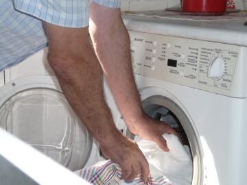 Un hombre introduce ropa en una lavadora doméstica, en una foto de archivo.