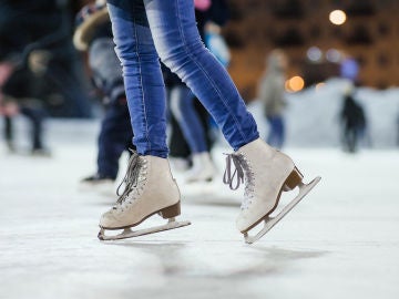Una persona patina sobre hielo en una pista exterior.