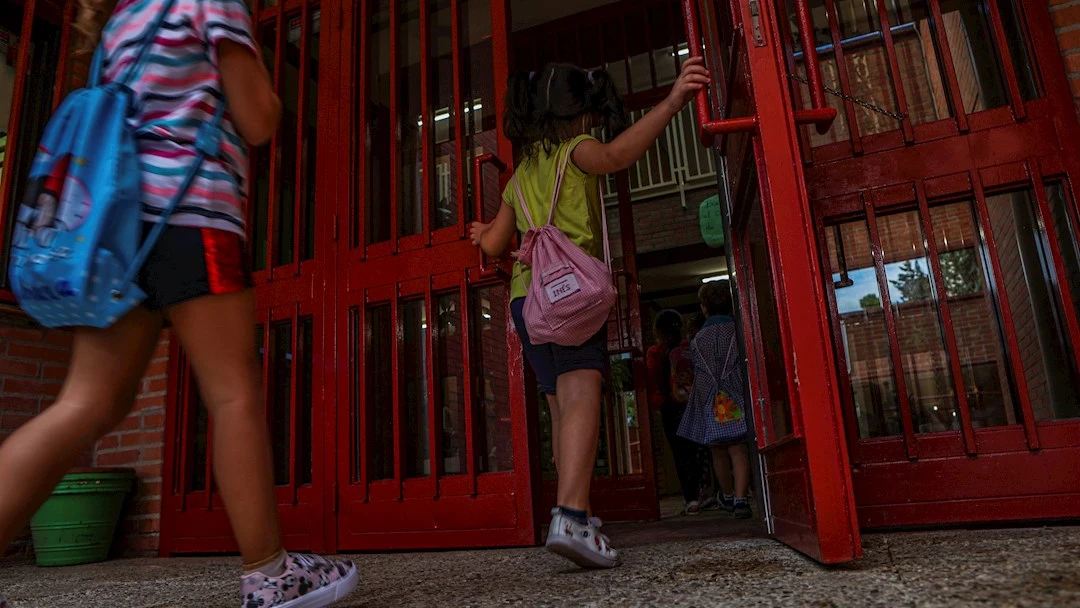 Varios alumnos entran en una colegio en una imagen de archivo Varios alumnos entran en una colegio en una imagen de archivo