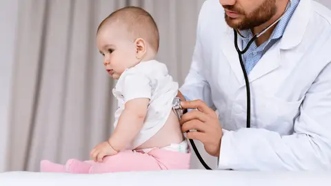 Un doctor, auscultando a un bebé. Un doctor, auscultando a un bebé.