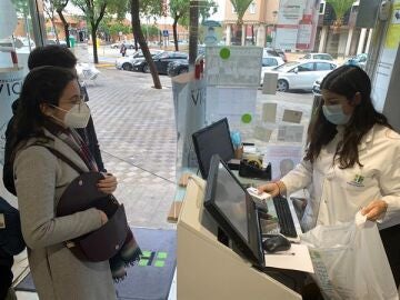 Una mujer compra un test de antígenos