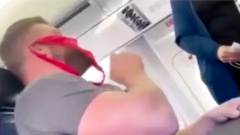 Expulsan de un avión a un hombre por llevar como mascarilla un tanga rojo Expulsan de un avión a un hombre por llevar como mascarilla un tanga rojo
