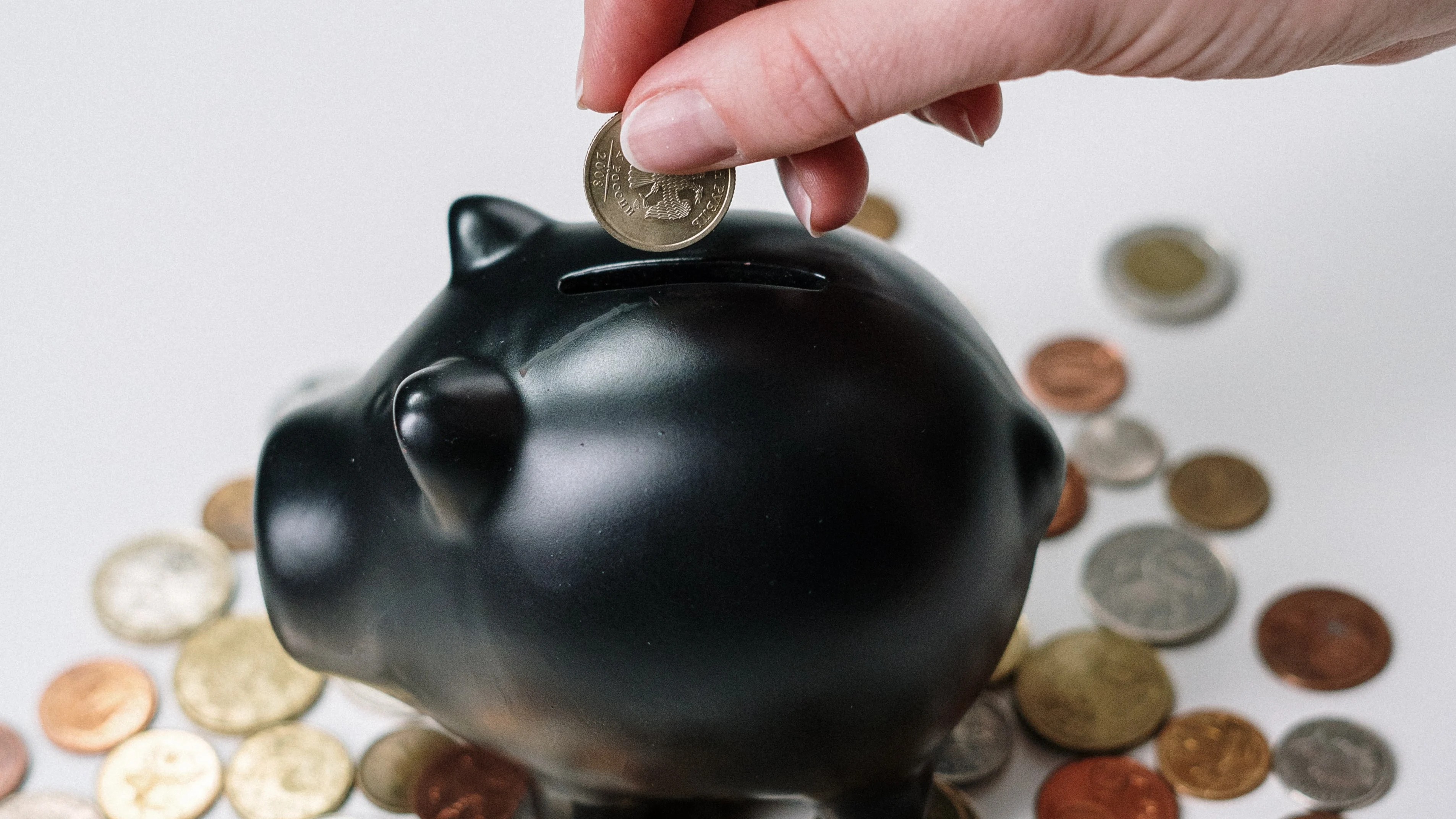 Imagen de una persona metiendo dinero en una hucha