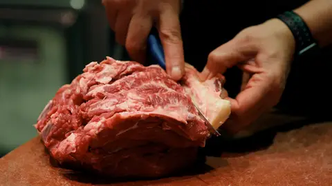 Dependiente corta la carne Dependiente corta la carne