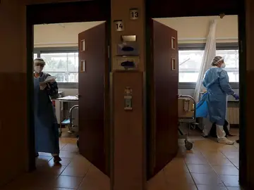 Dos sanitarias en un hospital atienden a pacientes de Covid, foto de archivo