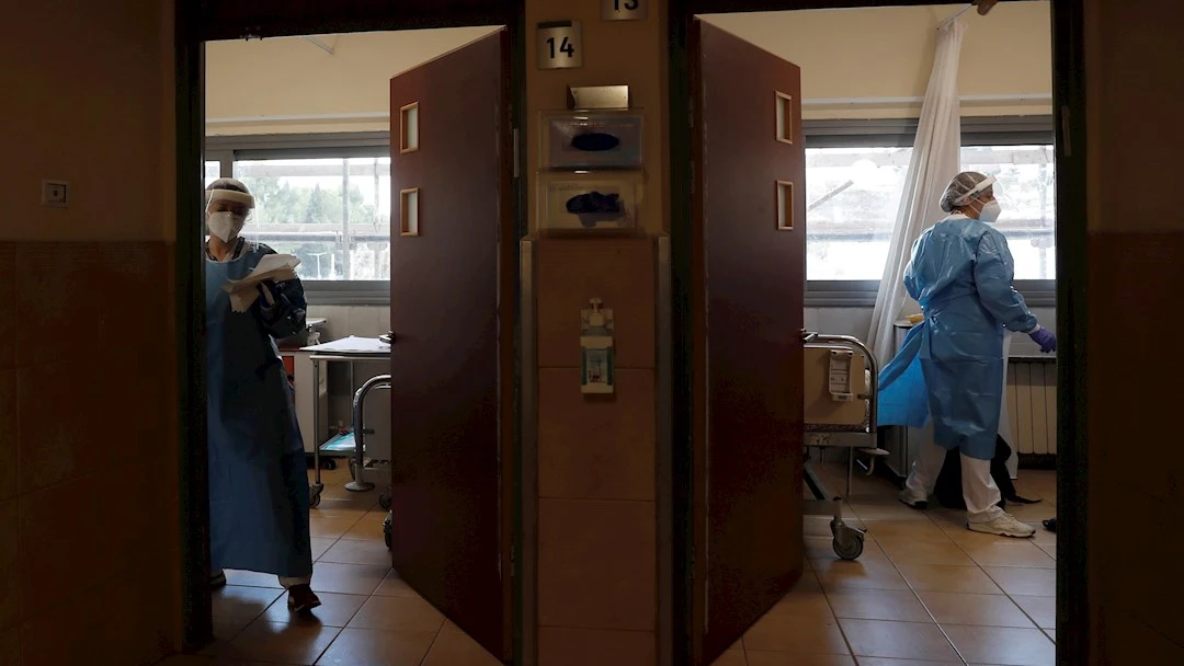 Dos sanitarias en un hospital atienden a pacientes de Covid, foto de archivo Dos sanitarias en un hospital atienden a pacientes de Covid, foto de archivo
