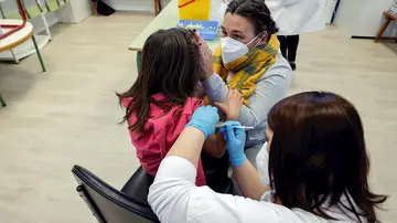 Una madre acompaña a su hija mientras la vacunan en el CEIP Blasco de Alagón de Vilafranca durante el inicio de la segunda fase de la campaña de vacunación pediátrica contra el coronavirus que comienza este jueves, centrada en los 186.088 niños y niñas de entre 8 y 5 años que estudian en los centros escolares de la Comunitat Valenciana.