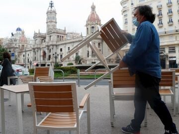 Un camarero coloca sillas y mesas en su local de la Plaza del Ayuntamiento de Valencia, en una fotografía de archivo