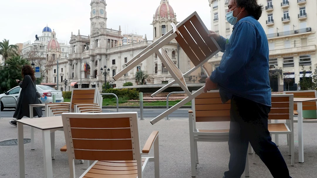 Un camarero coloca sillas y mesas en su local de la Plaza del Ayuntamiento de Valencia, en una fotograf&iacute;a de archivo