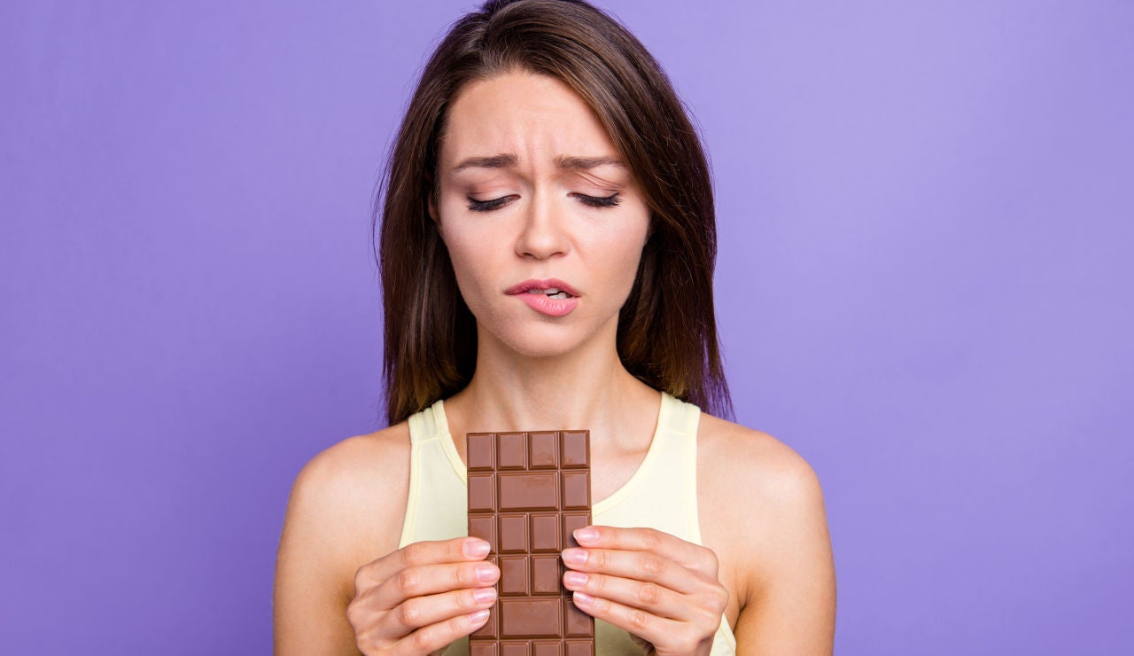 Chica con remordimientos por comer chocolate. 