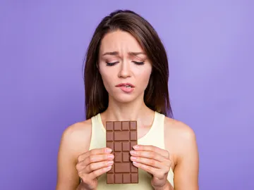 Chica con remordimientos por comer chocolate. Chica con remordimientos por comer chocolate.