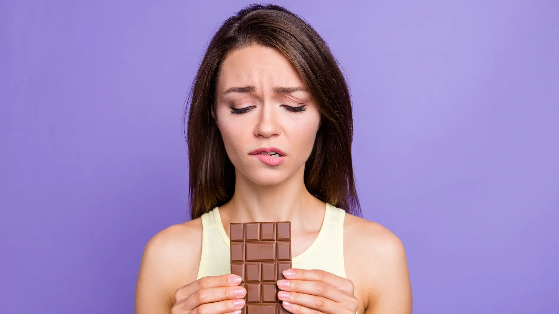 Chica con remordimientos por comer chocolate. 