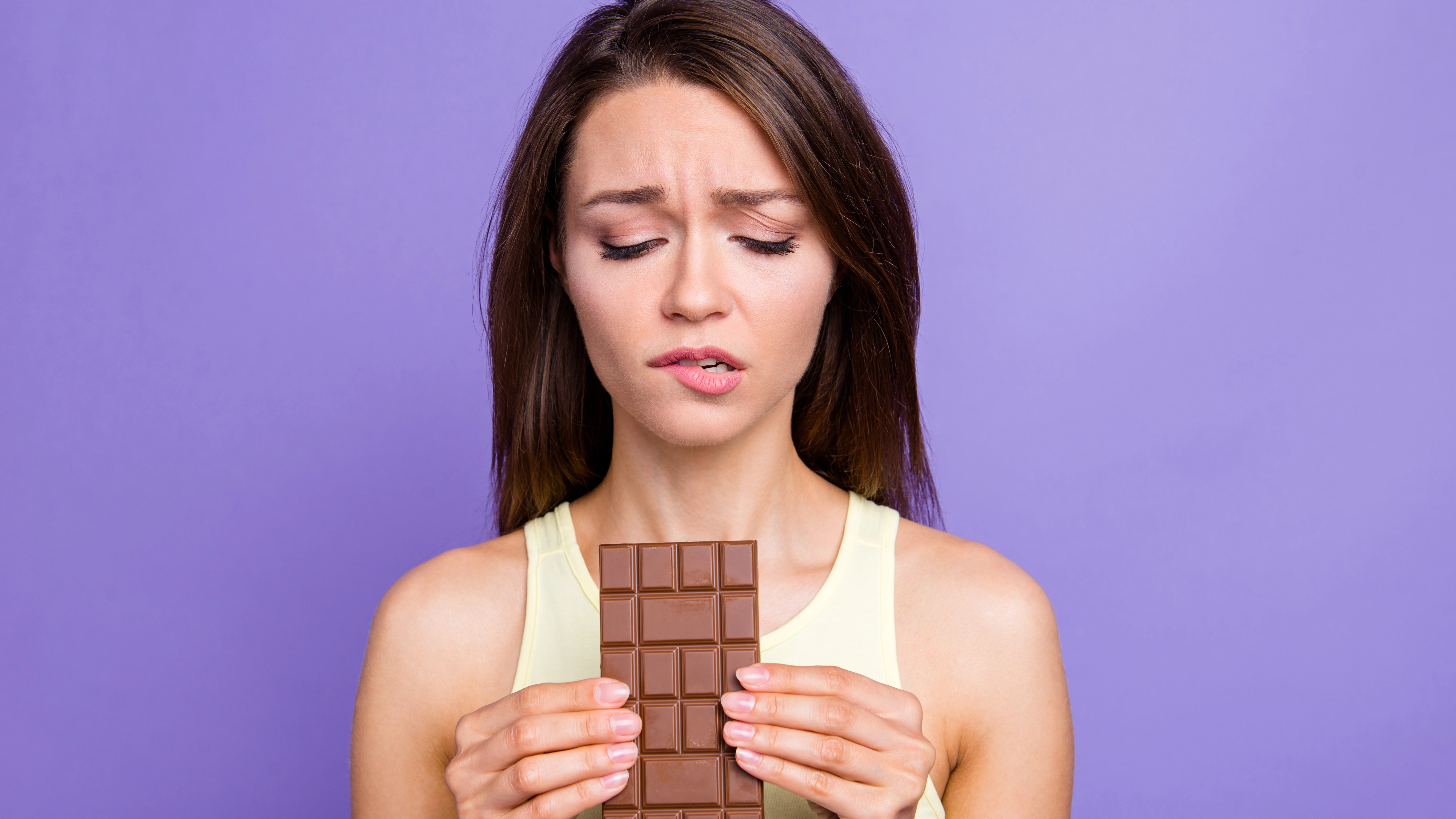 Chica con remordimientos por comer chocolate. 