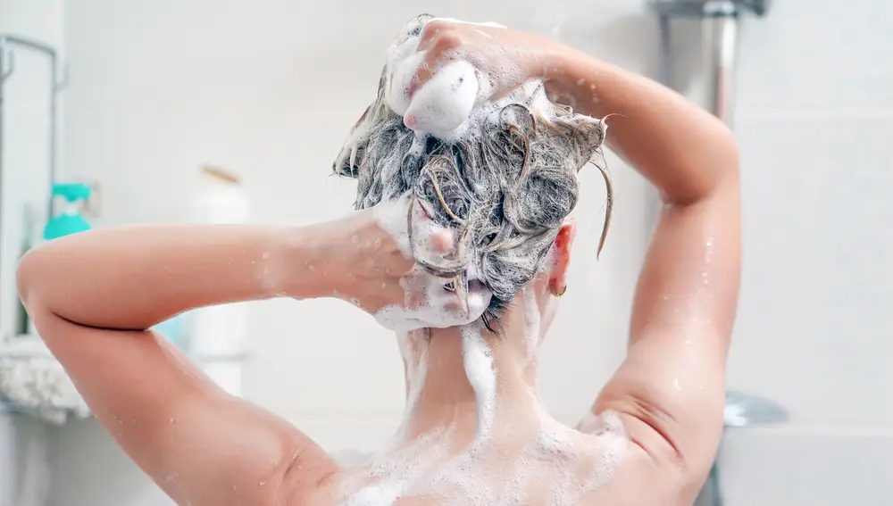 Chica lavándose el pelo. 