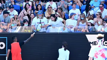 Kyrgios regalándole su raqueta a un niño