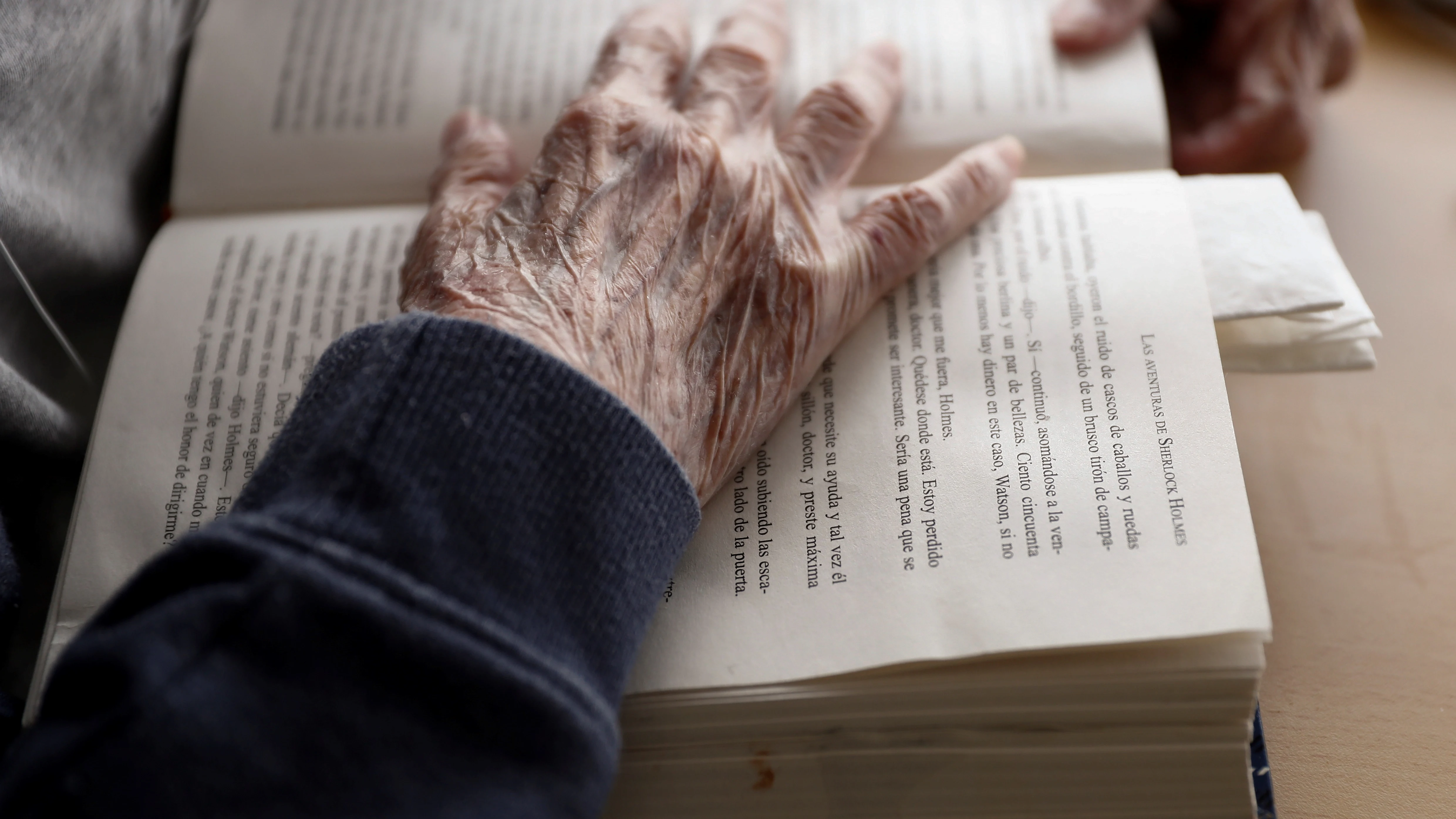 Anciano lee un libro en una residencia