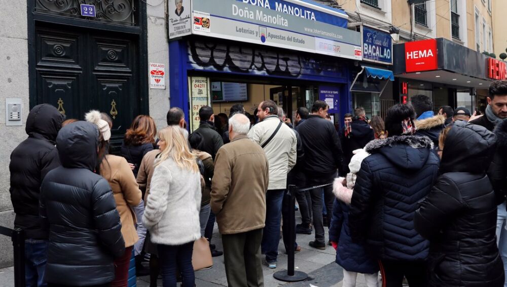 Varias personas hacen cola frente a la administración de lotería Doña Manolita, en Madrid, en una imagen de archivo