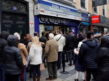 Varias personas hacen cola frente a la administración de lotería Doña Manolita, en Madrid Varias personas hacen cola frente a la administración de lotería Doña Manolita, en Madrid