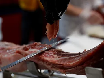 Imagen de archivo de un cortador preparando un plato con lascas de jamón ibérico Imagen de archivo de un cortador preparando un plato con lascas de jamón ibérico