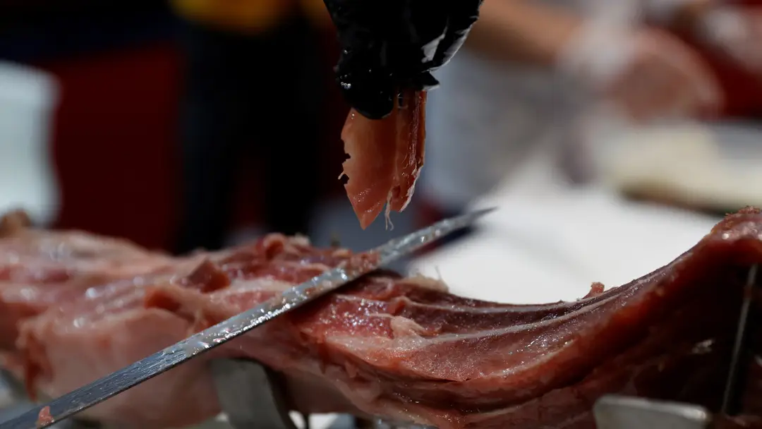 Imagen de archivo de un cortador preparando un plato con lascas de jam&oacute;n ib&eacute;rico